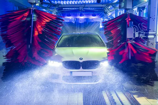 Automobilis tunelyje tarp tekstilinių šepečių